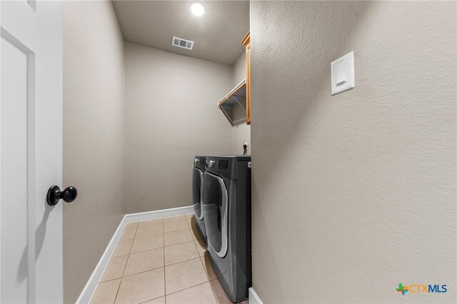 washroom featuring baseboards, visible vents, separate washer and dryer, laundry area, and light tile patterned floors