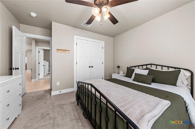 bedroom featuring light carpet, baseboards, visible vents, a ceiling fan, and a closet