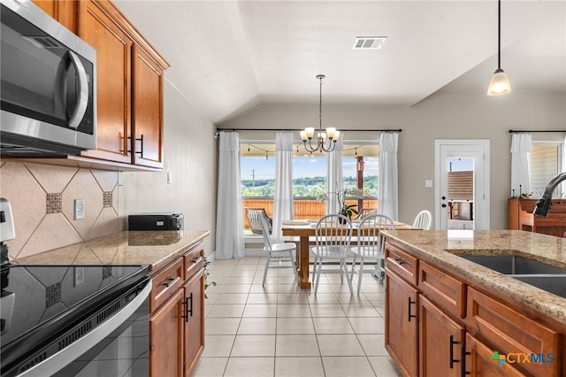 kitchen with vaulted ceiling, brown cabinets, an inviting chandelier, appliances with stainless steel finishes, and visible vents