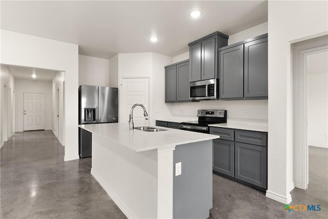 kitchen with sink, a center island with sink, gray cabinets, and appliances with stainless steel finishes