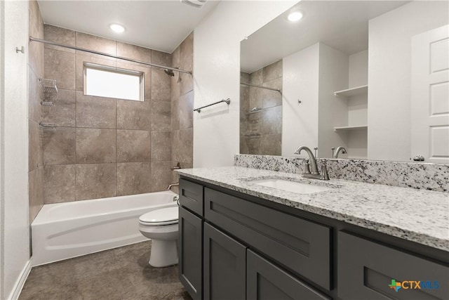 full bathroom featuring vanity, tiled shower / bath, and toilet