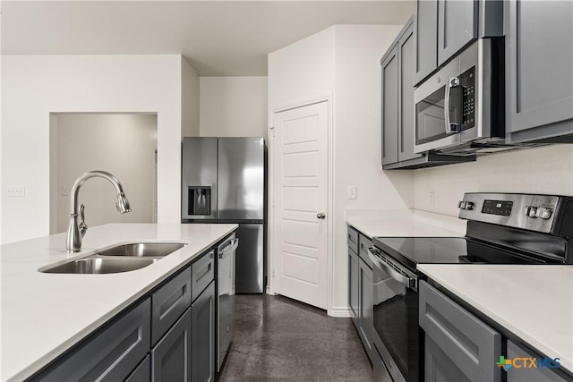 kitchen featuring stainless steel appliances, sink, and gray cabinetry