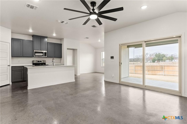 kitchen featuring sink, gray cabinets, ceiling fan, appliances with stainless steel finishes, and a center island with sink