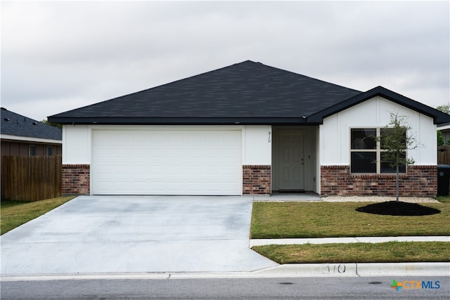 ranch-style home featuring a garage and a front lawn