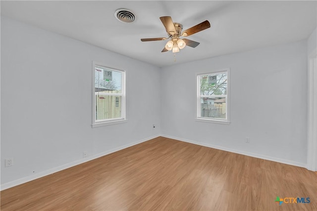 spare room with ceiling fan, a healthy amount of sunlight, and light hardwood / wood-style flooring