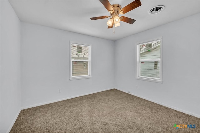 carpeted empty room with ceiling fan and a healthy amount of sunlight