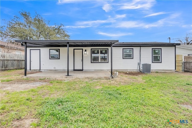 rear view of property featuring a yard, a patio area, and central AC