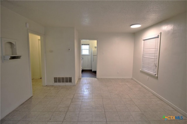 spare room with a textured ceiling