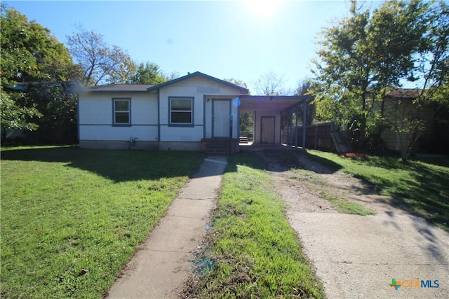 view of front of home with a front yard and a carport