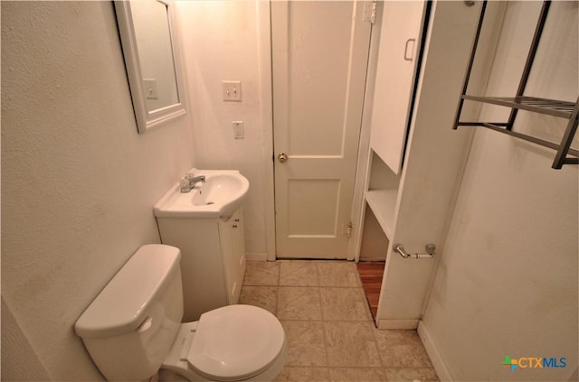 bathroom featuring tile patterned floors, vanity, and toilet