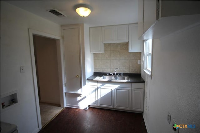 kitchen with backsplash, sink, white cabinets, and dark wood-type flooring