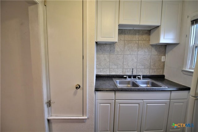 kitchen with tasteful backsplash, sink, and white cabinets