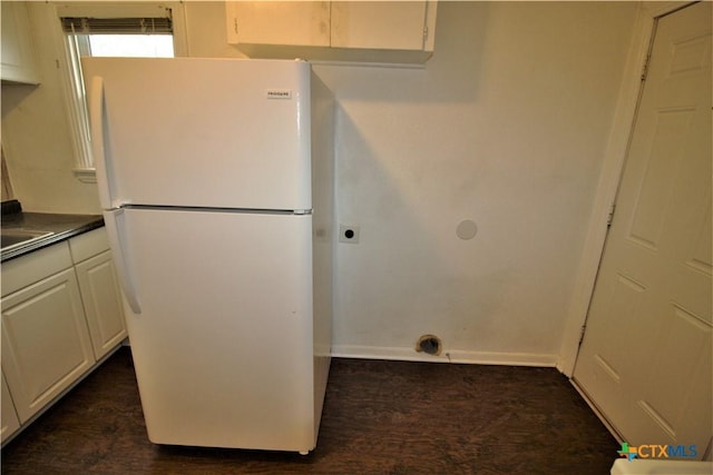 kitchen featuring white cabinets and white fridge