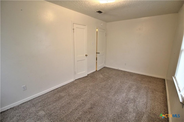 carpeted spare room featuring a textured ceiling