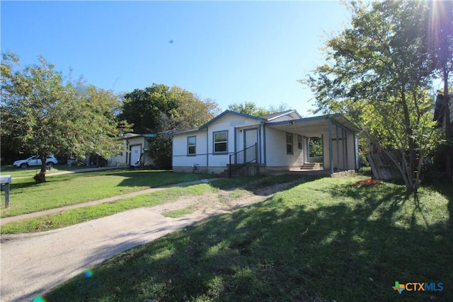 view of side of property featuring a carport and a yard