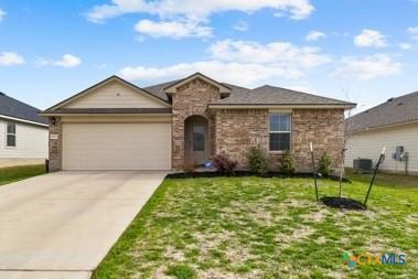8508 Cantera Ridge Rd, Temple, TX 76502 - view of front facade featuring a garage, driveway, a front yard, and stone siding