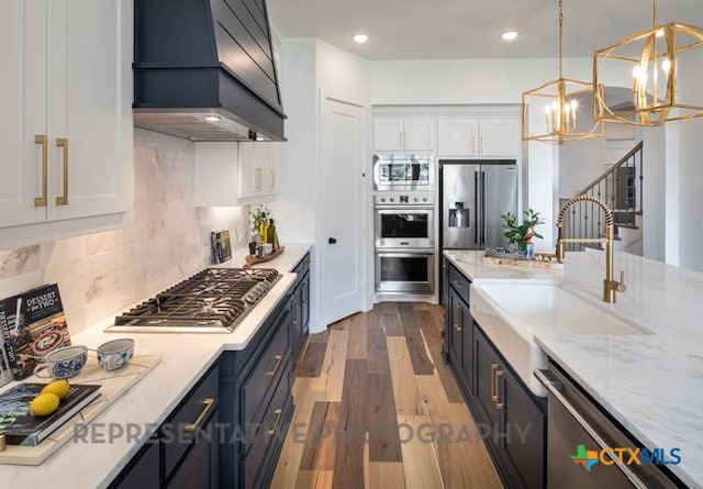 322 Dulce Vis, Boerne, TX 78006 - kitchen featuring appliances with stainless steel finishes, custom range hood, a sink, a chandelier, and white cabinets