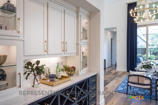 322 Dulce Vis, Boerne, TX 78006 - kitchen with a chandelier, white cabinetry, light wood-style flooring, and glass insert cabinets