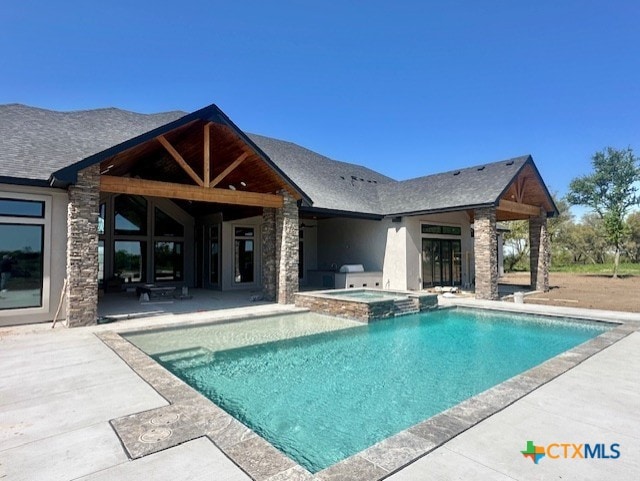 view of pool with a pool with connected hot tub and a patio