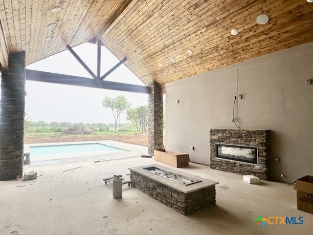 view of patio with an outdoor pool and a fire pit