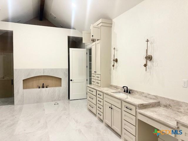 full bathroom with a sink and vaulted ceiling with beams