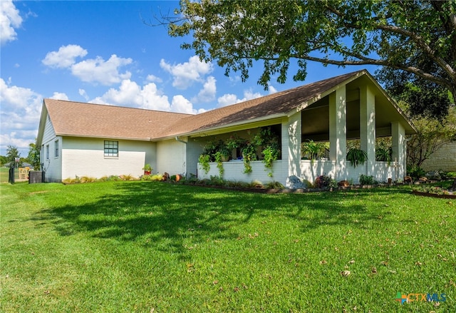 view of front of property with central AC unit and a front lawn