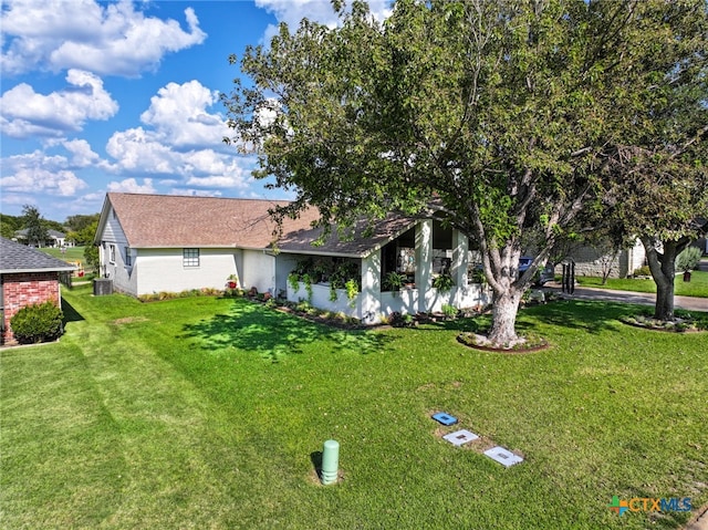 exterior space with central AC unit and a front yard