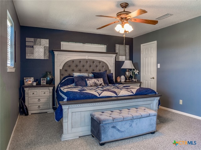 carpeted bedroom with a textured ceiling and ceiling fan