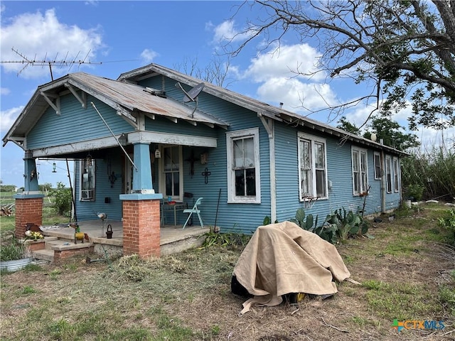 back of property with a porch