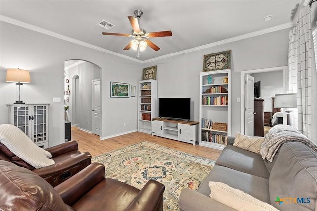 living room featuring a large fireplace, ceiling fan, light hardwood / wood-style floors, and crown molding