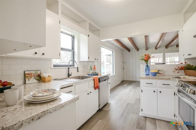 kitchen with white cabinets, light wood-style flooring, a sink, stainless steel appliances, and beam ceiling