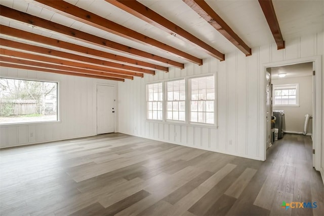 unfurnished living room featuring beam ceiling and wood finished floors