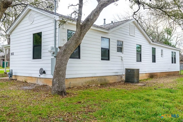 view of home's exterior featuring central air condition unit and a yard