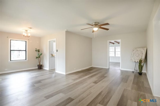 empty room featuring ceiling fan, wood finished floors, and baseboards