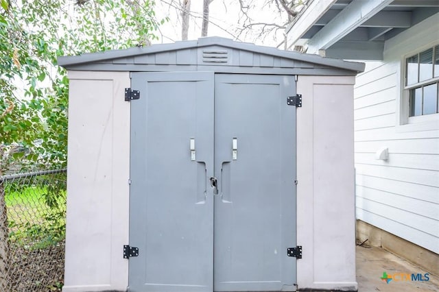 view of shed featuring fence