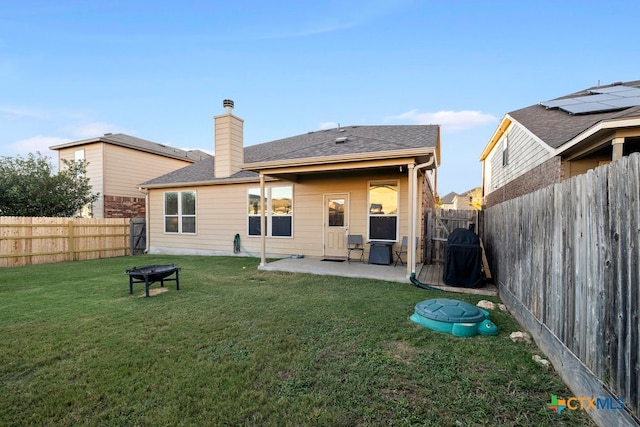 rear view of house with a patio area and a lawn