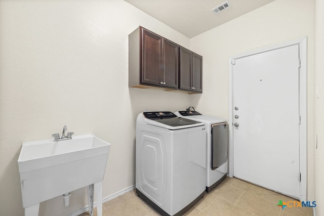 laundry room featuring washing machine and dryer, cabinets, and sink