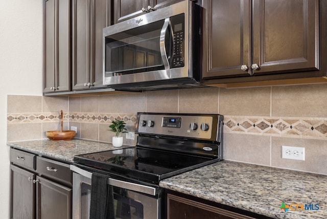 kitchen with light stone countertops, appliances with stainless steel finishes, decorative backsplash, and dark brown cabinets