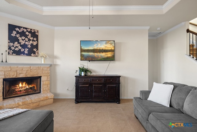 tiled living room featuring a fireplace, a raised ceiling, and crown molding