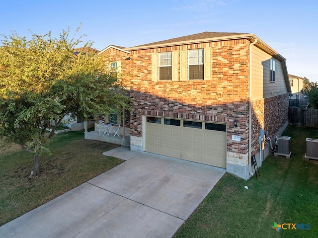 view of front of property with a garage, central AC, and a front yard