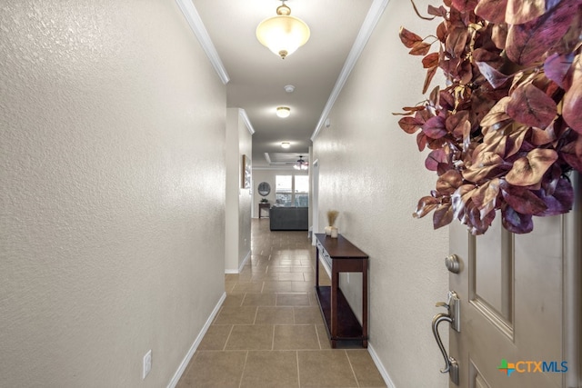 hallway with dark tile patterned floors and crown molding