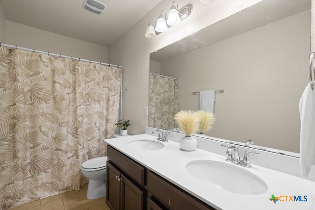 bathroom featuring vanity, tile patterned flooring, and toilet