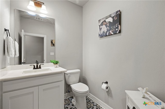 bathroom with toilet, tile patterned floors, and vanity