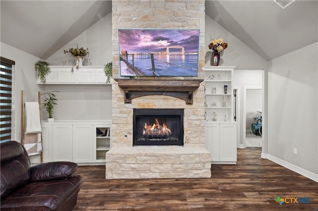 living room with lofted ceiling, dark hardwood / wood-style floors, and a stone fireplace