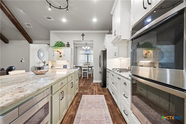 kitchen with light stone counters, stainless steel appliances, backsplash, and white cabinetry