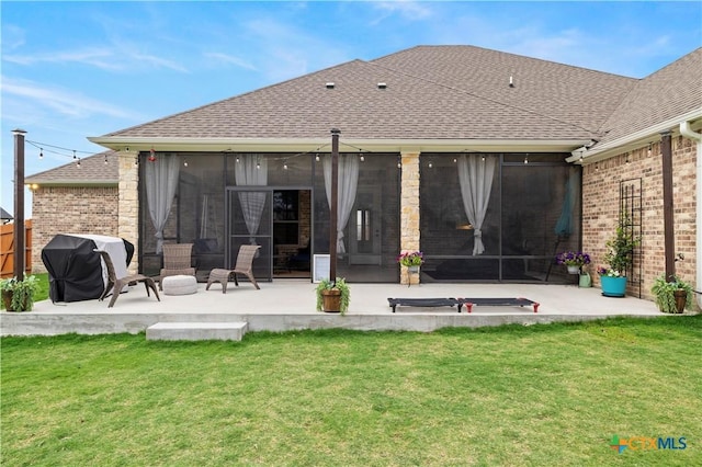 back of property featuring a patio, a yard, and a sunroom