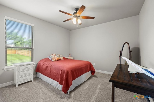 carpeted bedroom featuring ceiling fan and multiple windows