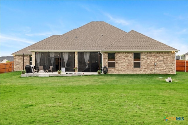 back of house featuring a yard, a patio, and a sunroom