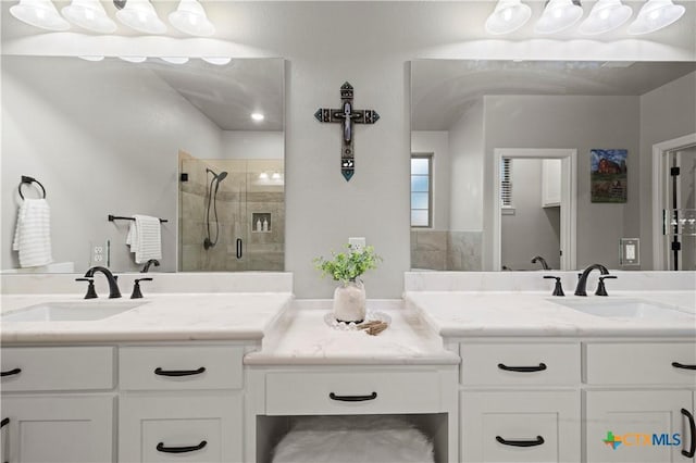 bathroom featuring a shower with door and vanity