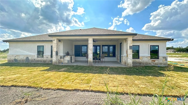 rear view of property featuring ceiling fan, a lawn, and a patio area